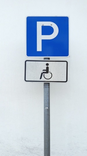 Das Verkehrszeichen für einen Behindertenparkplatz ist meist ein Parkplatzschild mit Zusatzzeichen.