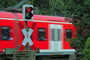 Ein Andreaskreuz mit rotem Blinklicht bedeutet, dass Sie dem Schienenverkehr Vorrang gewähren müssen.